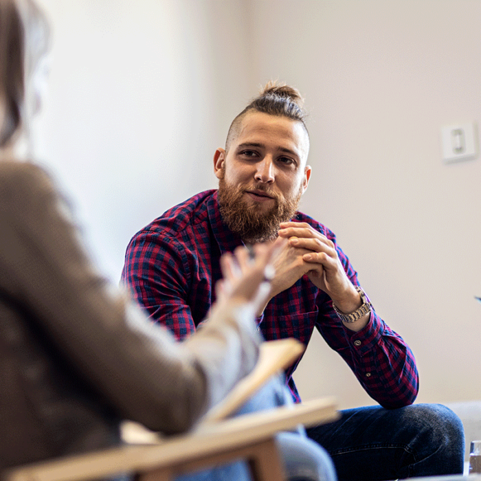 young man engaged in therapy session with addiction specialist and asks how long does an alcohol rehab program last