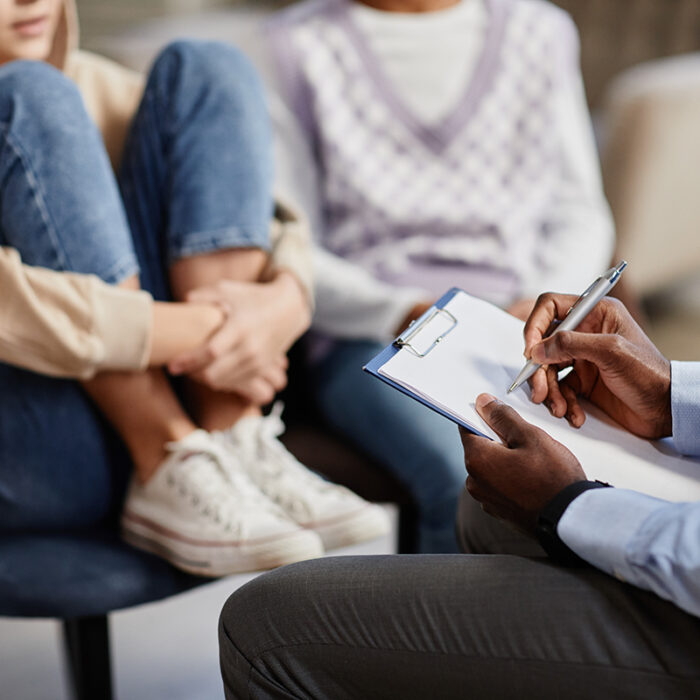 group of men and women gathered around a therapist asking could my family benefit from therapy