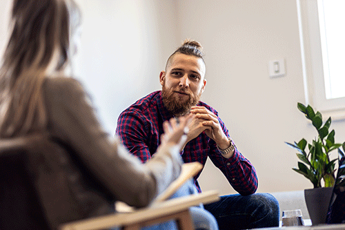 young man talking during group session as part of a prescription drug treatment program