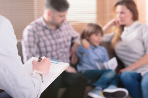therapist talking to youthful parents and their young son about what is family therapy