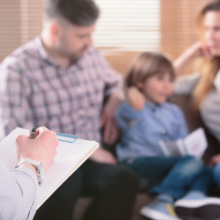 therapist talking to youthful parents and their young son about what is family therapy