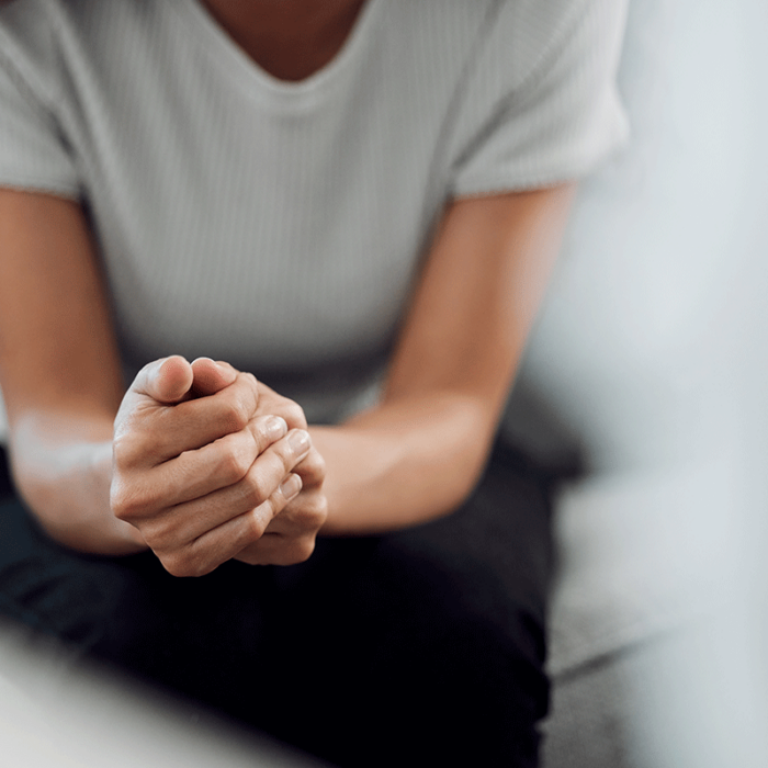 person seated in therapist's office with hands clasped in front of them wondering how can you help someone with a cocaine addiction