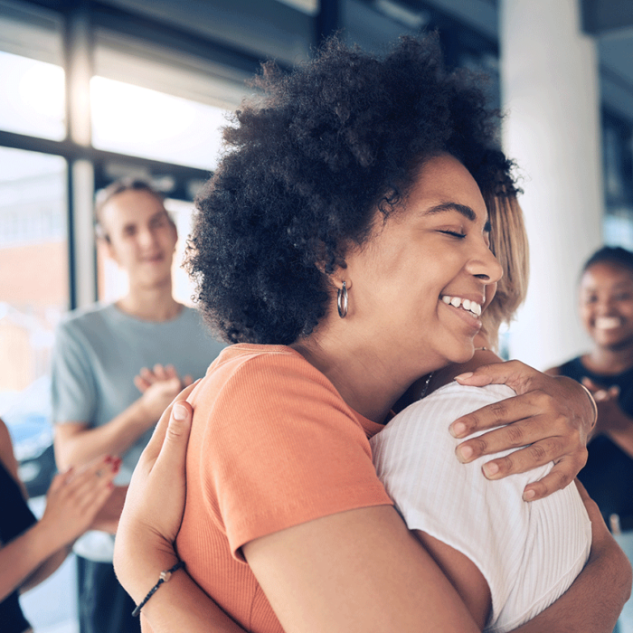 woman hugging therapist at group therapy session after asking what are 5 benefits of dual diagnosis treatment