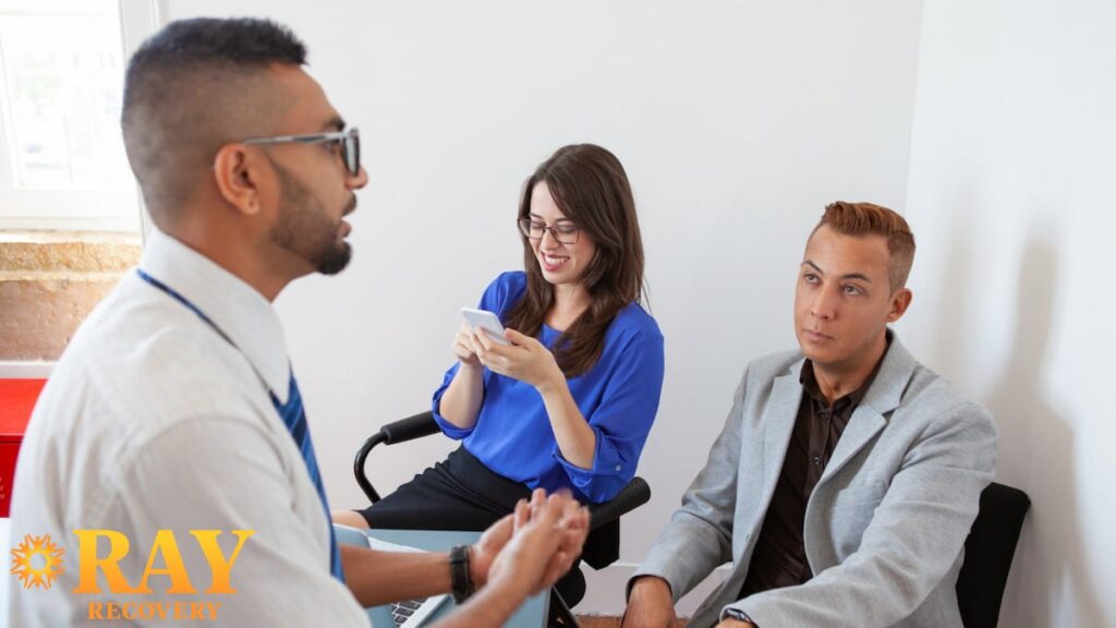 Counselor leading a small group therapy session with two adults